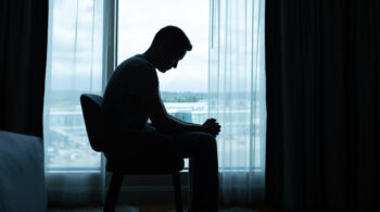 Sad man sitting in the dark room. depressione